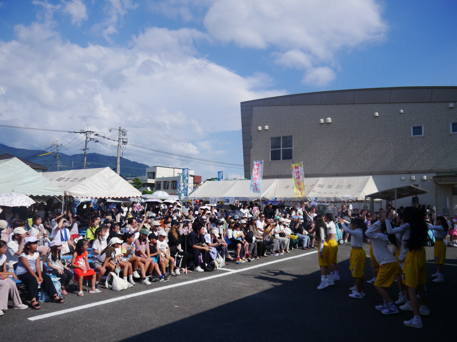 青空のもと大勢の来場者で賑わう夏まつり会場